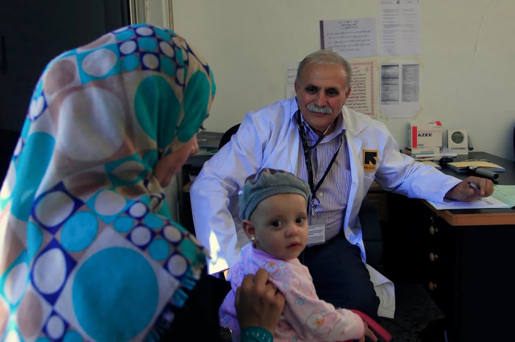 A doctor at an International Rescue Committee clinic in Ramtha, northern Jordan, conducts a check-up on a young Syrian refugee. The UK is supporting IRC to deli