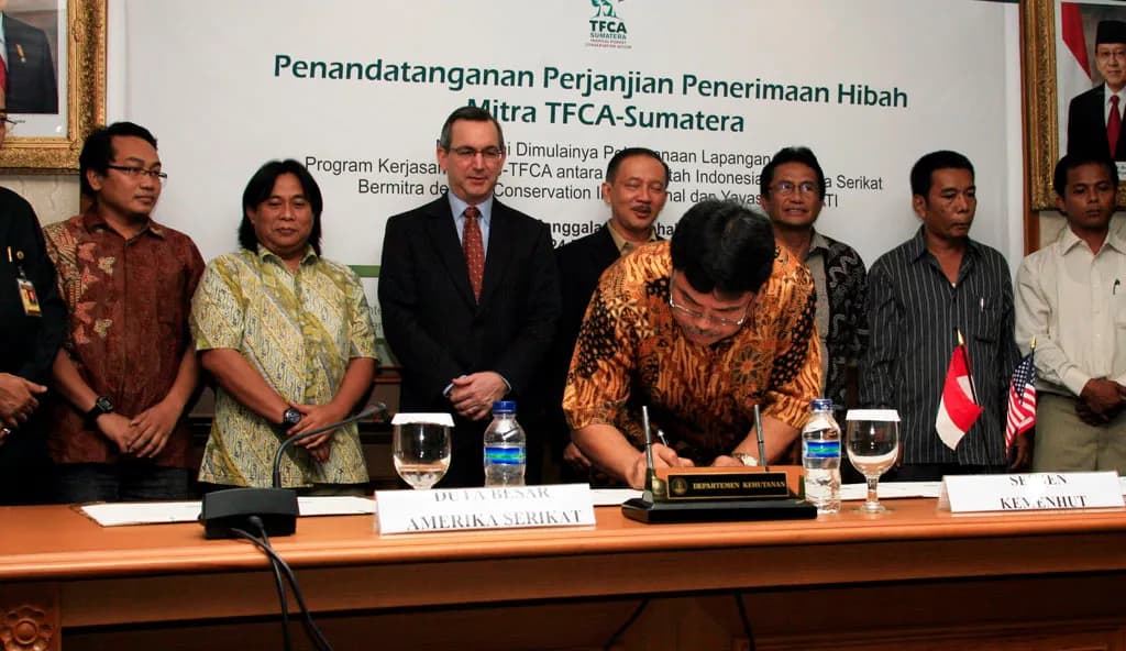 U.S. Ambassador to Indonesia, Scot Marciel (third from left), representatives from the government of Indonesia and 5 local NGO signatories witness the signing o
