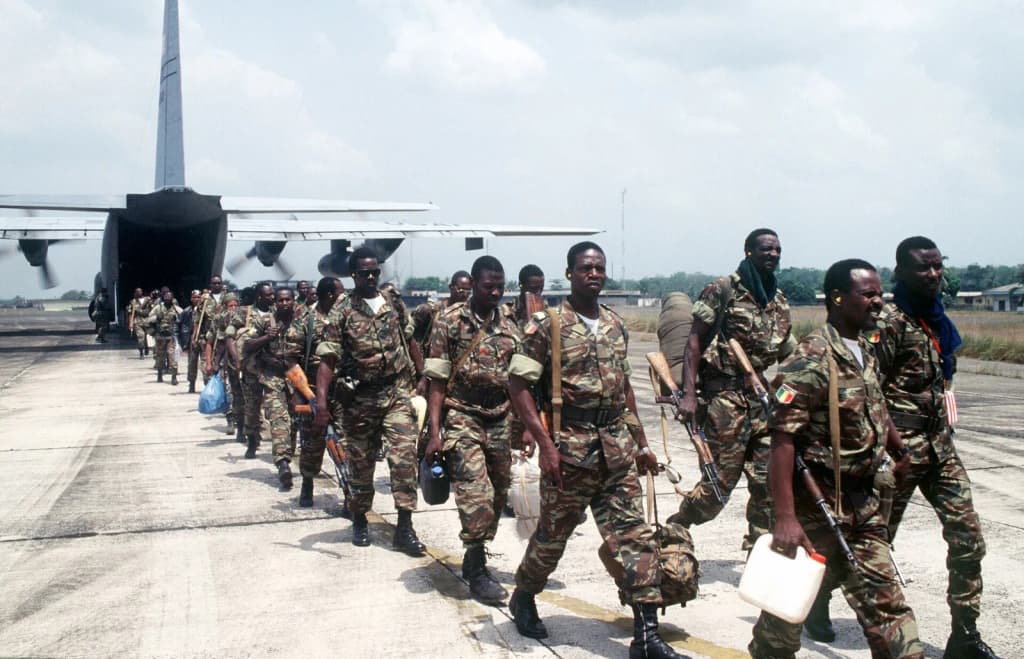 Economic Community Military Observation Group 13 (ECOMOG) Mali Army Troops (armed with AK 47 assault rifles) come off of a US Air Force C-130E Hercules assigned