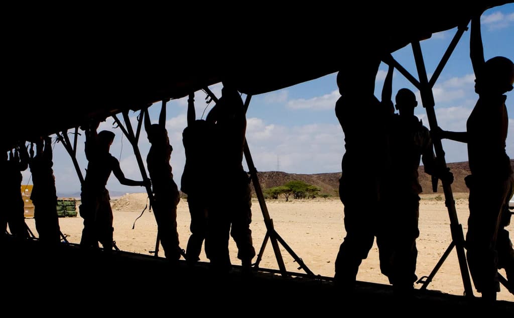 Sailors from Combined Joint Task Force - Horn of Africa and soldiers of the Djiboutian army raise the wall of a 64-foot temper tent, Nov. 2, on a range of Doudo