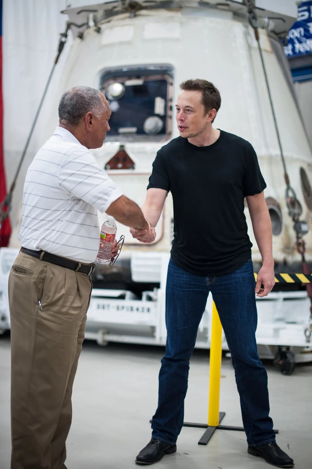 NASA Administrator Charles Bolden, left, congratulates SpaceX CEO and Chief Designer Elon Musk in front of the historic Dragon capsule that returned to Earth on