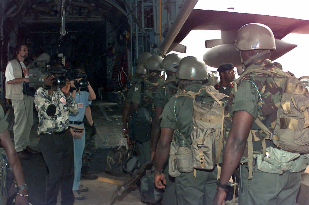 Economic Community Military Observation Group 13 (ECOMOG) Ghana Army Troops prepare to board a United States Air Force C-130E Hercules aircraft assigned to the