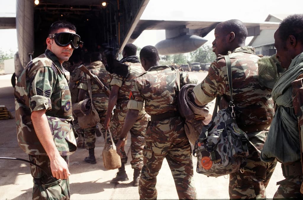 A U.S. Air Force Staff Sergeant assists Mali Army troops from the Economic Community Military Observation Group 13 (ECOMOG) Mali Army troops as they board a U.S