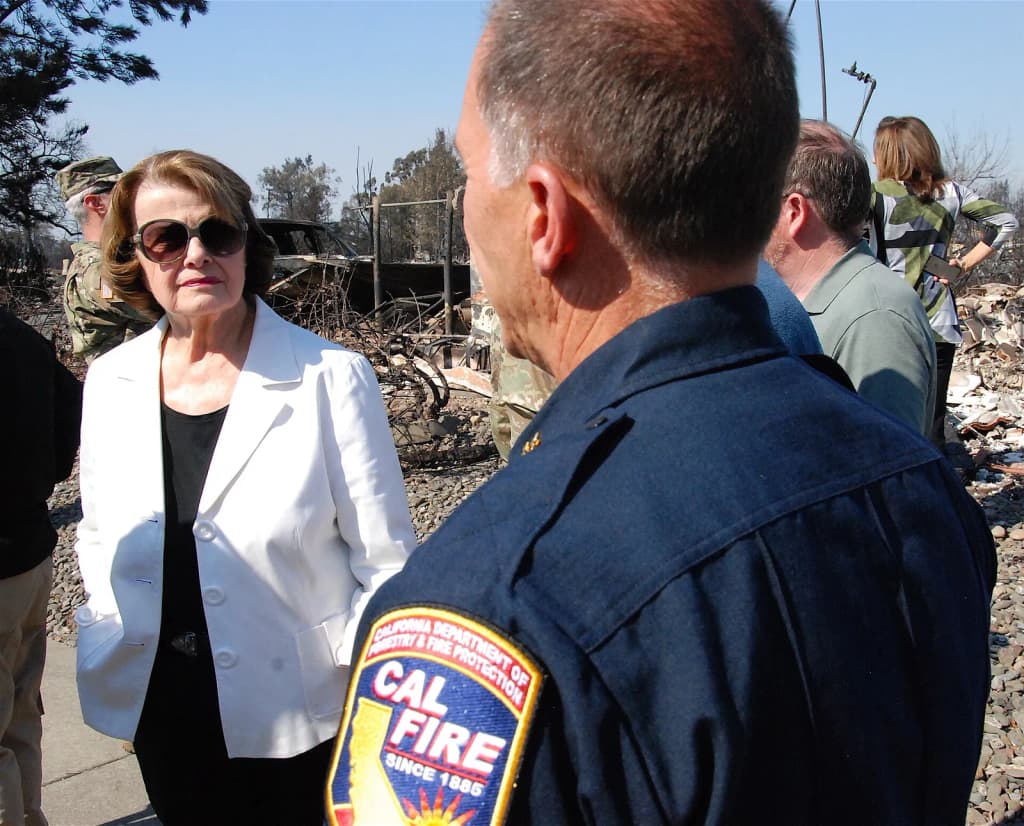 CAL FIRE director Chief Ken Pimlott, right, speaks with U.S. Sen. Diane Feinstein as they survey the damage caused by the wildfires in Santa Rosa, California, o