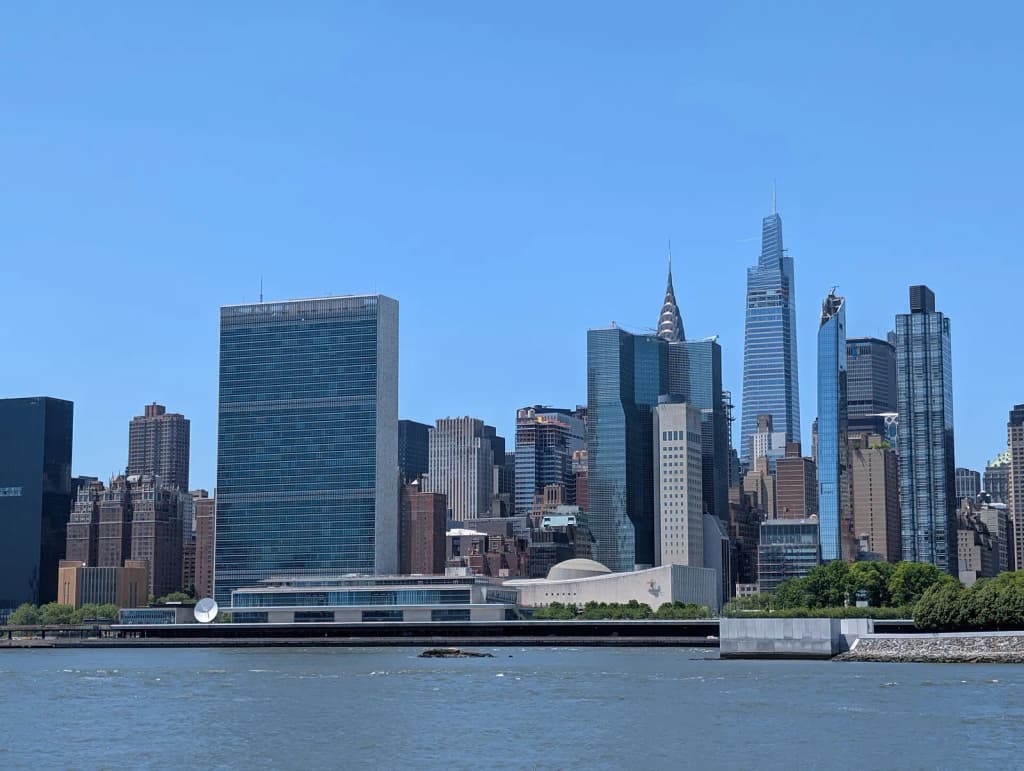The United Nations Headquarters and United Nations Visitors Services buildings as viewed from Long Island City's Riverwalk park.