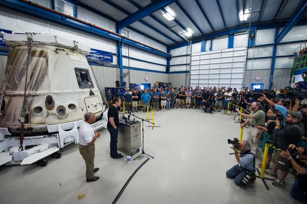NASA Administrator Charles Bolden, left, and SpaceX CEO and Chief Designer Elon Musk, view the historic Dragon capsule that returned to Earth on May 31 followin