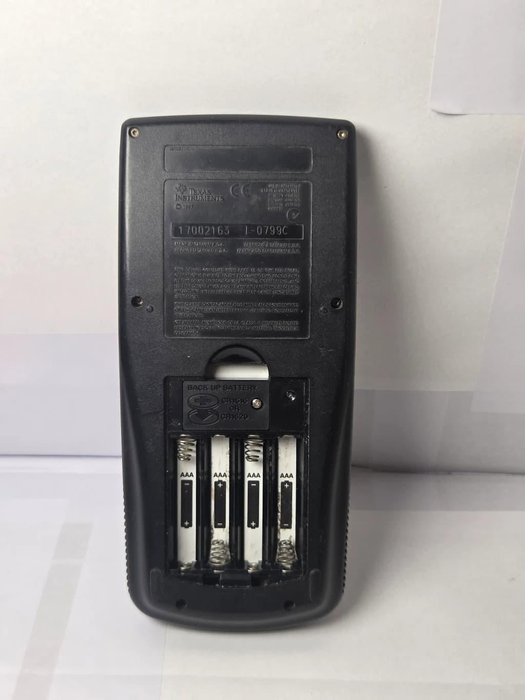 Rear view (battery compartment) of a Texas Instruments TI-89 Graphing Calculator (with slide cover, 1997 model).