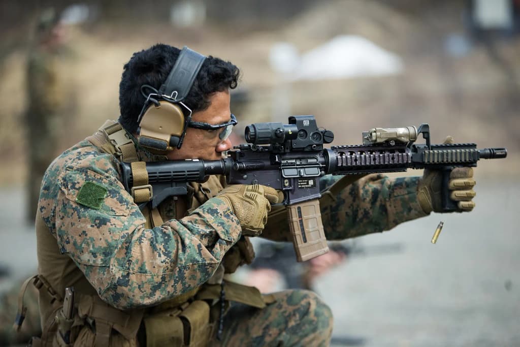 A U.S. Marine with 1st Platoon, Force Reconnaissance Company, 2nd Reconnaissance Battalion, 2nd Marine Division, fires downrange amid an immediate action drill