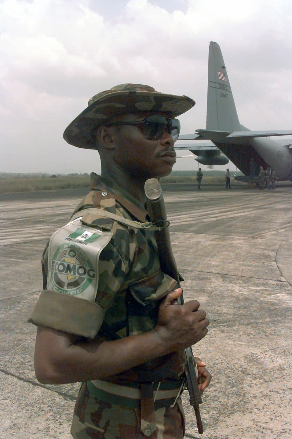 A Economic Community Military Observation Group (ECOMOG) Nigerian Army troop provides security for ECOMOG Mali Army personnel as they come off a United States A