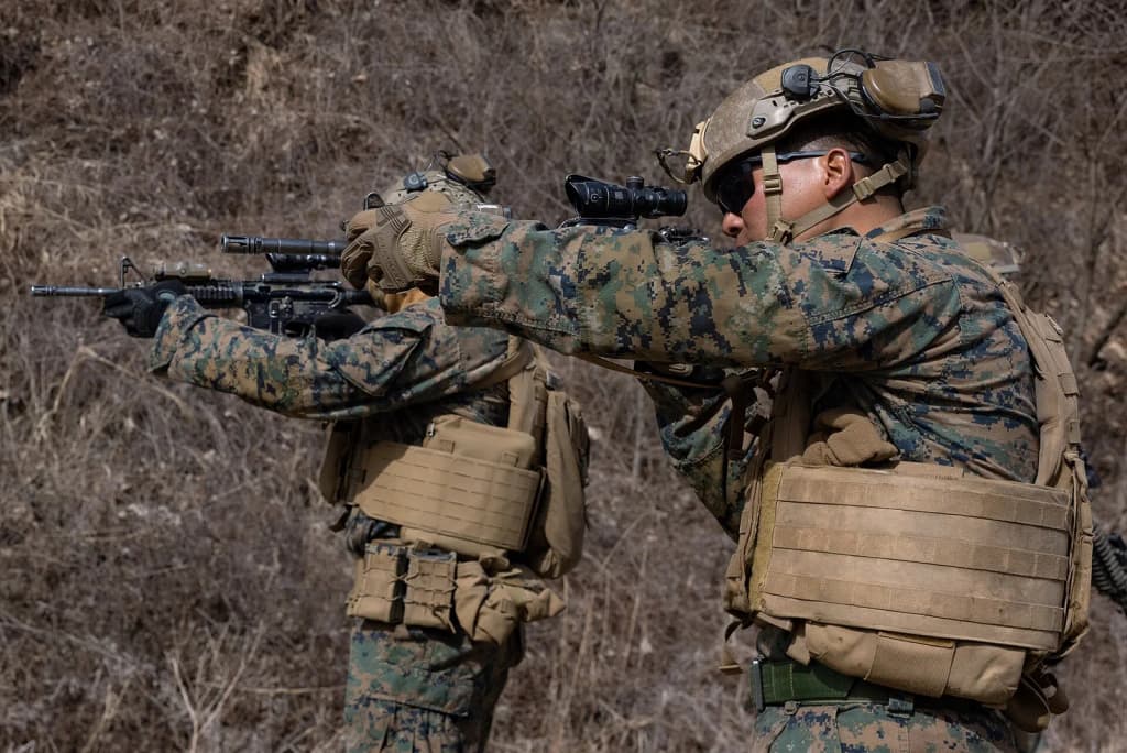 U.S. Marine Corps Lance Cpl. Jigme Dorjee, right, a field artillery cannoneer with 3d Battalion, 12th Marine Regiment, 3d Marine Division sights into his M4 car